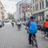 People wearing helmets and bicycling along a street
